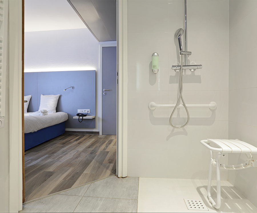 Modified bathroom for elderly and disabled people with a grab rail and fold down shower seat